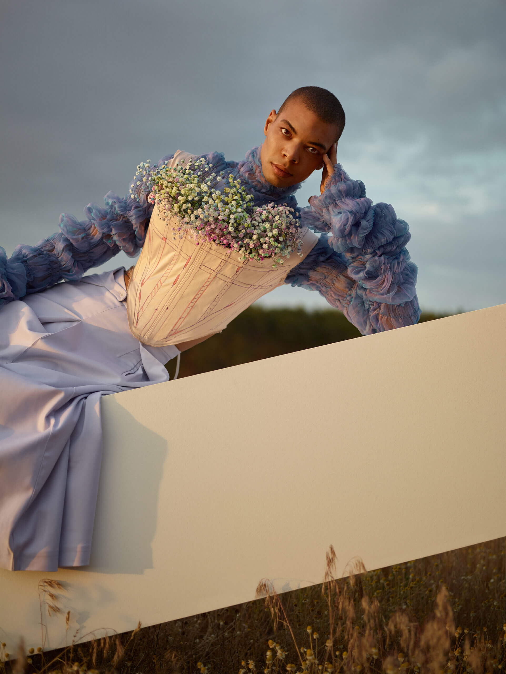 Set Design eine Frau in einem blauen Kleid, die sich an ein weißes Schild lehnt